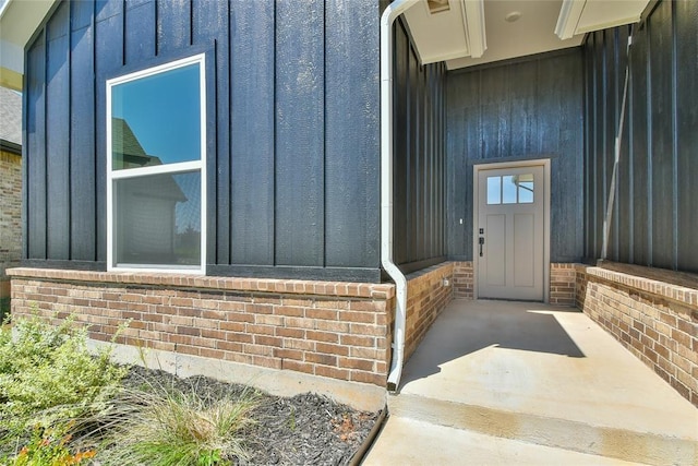 10617 Little Sallisaw Creek Dr, Yukon, OK 73099 - doorway to property with board and batten siding and brick siding