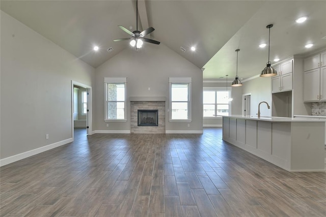 10617 Little Sallisaw Creek Dr, Yukon, OK 73099 - unfurnished living room with high vaulted ceiling, ceiling fan, a stone fireplace, dark wood-style flooring, and recessed lighting