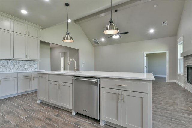 10617 Little Sallisaw Creek Dr, Yukon, OK 73099 - kitchen with stainless steel dishwasher, tasteful backsplash, light countertops, beam ceiling, and an island with sink
