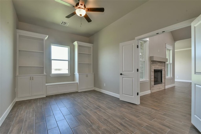 10617 Little Sallisaw Creek Dr, Yukon, OK 73099 - unfurnished room featuring plenty of natural light, ceiling fan, dark wood-style flooring, and a fireplace