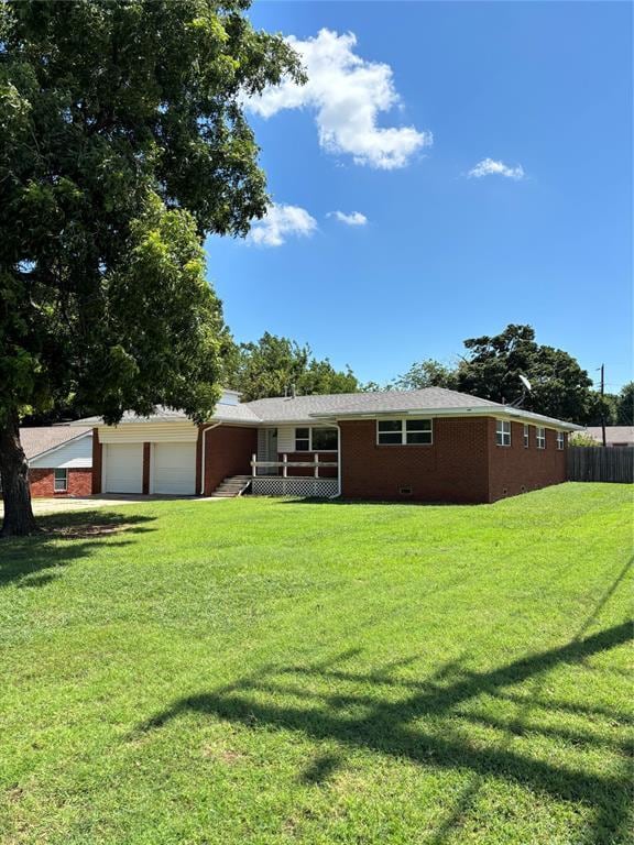 611 Garth Brooks Blvd, Yukon, OK 73099 - back of house with brick siding, a garage, and a wooden deck