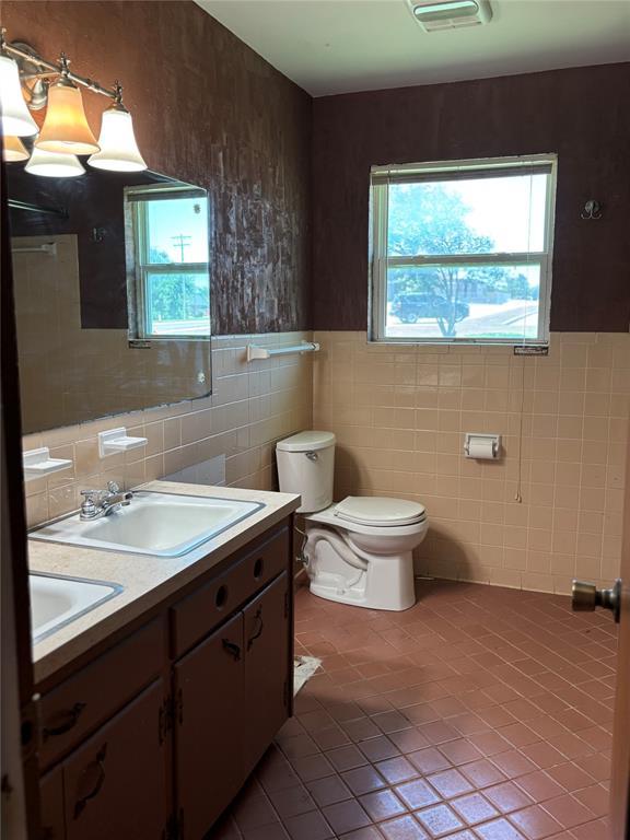 611 Garth Brooks Blvd, Yukon, OK 73099 - bathroom featuring tile walls, tile patterned floors, double vanity, and wainscoting