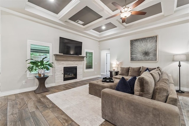 8040 Sweetgum St, Edmond, OK 73034 - living area with ceiling fan, crown molding, coffered ceiling, a stone fireplace, and wood finished floors