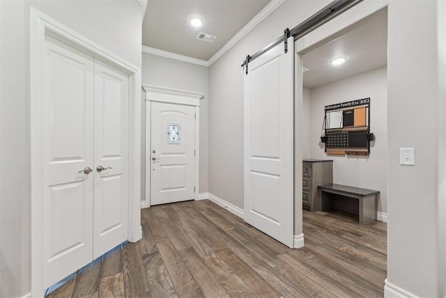 8040 Sweetgum St, Edmond, OK 73034 - foyer with crown molding, a barn door, and dark wood finished floors