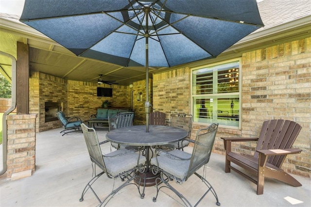 8040 Sweetgum St, Edmond, OK 73034 - view of patio with an outdoor brick fireplace, a ceiling fan, and outdoor dining space