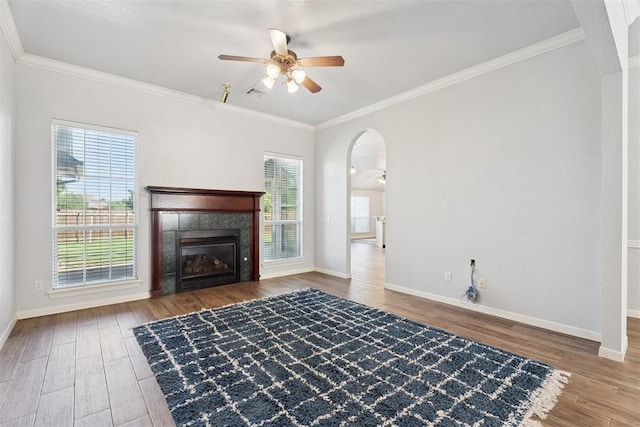 3343 Teton Cir, Norman, OK 73072 - unfurnished living room featuring a ceiling fan, wood finished floors, arched walkways, crown molding, and a fireplace