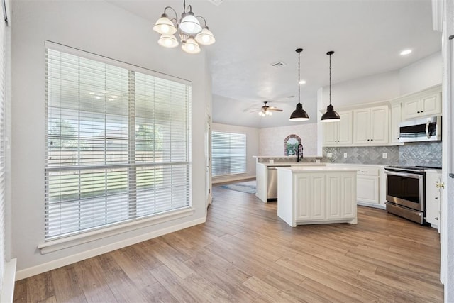 3343 Teton Cir, Norman, OK 73072 - kitchen featuring appliances with stainless steel finishes, ceiling fan, light countertops, tasteful backsplash, and a chandelier