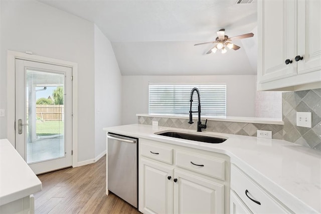 3343 Teton Cir, Norman, OK 73072 - kitchen featuring stainless steel dishwasher, vaulted ceiling, healthy amount of natural light, tasteful backsplash, and light wood-style flooring