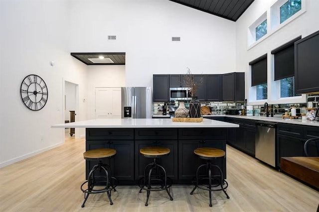 156 Butternut Trl, Broken Bow, OK 74728 - kitchen with appliances with stainless steel finishes, high vaulted ceiling, light countertops, a breakfast bar, and a kitchen island