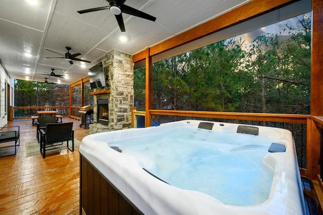 156 Butternut Trl, Broken Bow, OK 74728 - deck with an outdoor stone fireplace, a hot tub, and ceiling fan