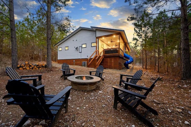 156 Butternut Trl, Broken Bow, OK 74728 - back of house at dusk with a fire pit and stairs