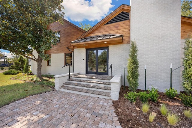 1725 Huntington Ave, Nichols Hills, OK 73116 - doorway to property featuring a standing seam roof, a metal roof, brick siding, and a chimney