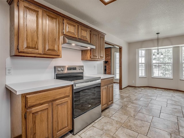 400 Ryan Way, Edmond, OK 73003 - kitchen with stainless steel electric range, under cabinet range hood, brown cabinetry, a chandelier, and a textured ceiling