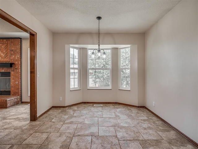 400 Ryan Way, Edmond, OK 73003 - unfurnished dining area with a textured ceiling, a chandelier, a fireplace, and light stone finish floors