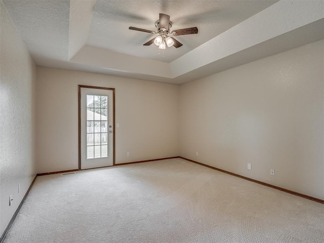 400 Ryan Way, Edmond, OK 73003 - spare room featuring light colored carpet, a ceiling fan, a tray ceiling, and a textured ceiling