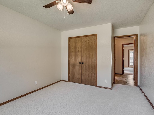 400 Ryan Way, Edmond, OK 73003 - unfurnished bedroom featuring a textured ceiling, a closet, carpet, and ceiling fan