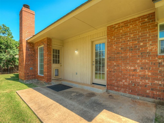 400 Ryan Way, Edmond, OK 73003 - entrance to property with a chimney, a lawn, a patio, and brick siding