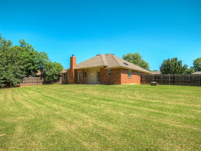 400 Ryan Way, Edmond, OK 73003 - back of house featuring a chimney, a fenced backyard, and brick siding