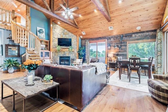 39 E Shore Dr, Arcadia, OK 73007 - living room with a wood ceiling with exposed beams, wood-type flooring, stairs, a stone fireplace, and a ceiling fan