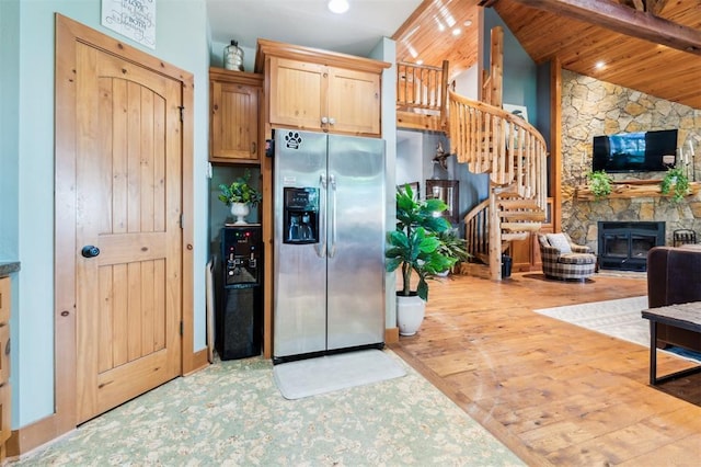 39 E Shore Dr, Arcadia, OK 73007 - kitchen with stainless steel fridge, a fireplace, open floor plan, wood finished floors, and light brown cabinets