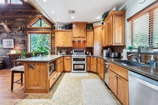39 E Shore Dr, Arcadia, OK 73007 - kitchen featuring appliances with stainless steel finishes, healthy amount of natural light, a breakfast bar area, decorative backsplash, and recessed lighting