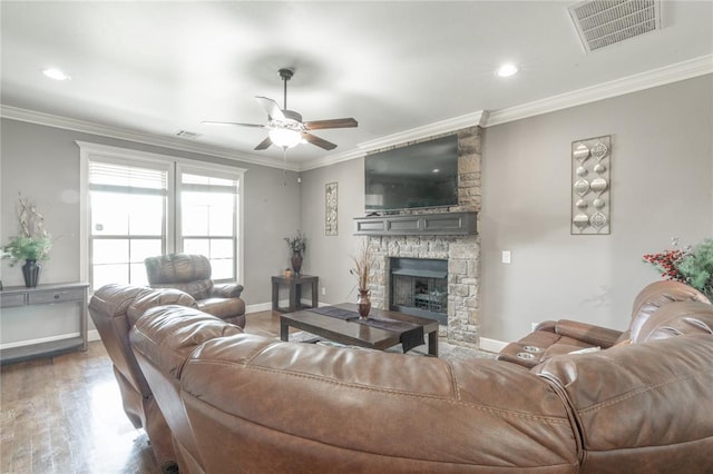 9409 NW 91st St, Yukon, OK 73099 - living room with a ceiling fan, crown molding, wood finished floors, a stone fireplace, and recessed lighting