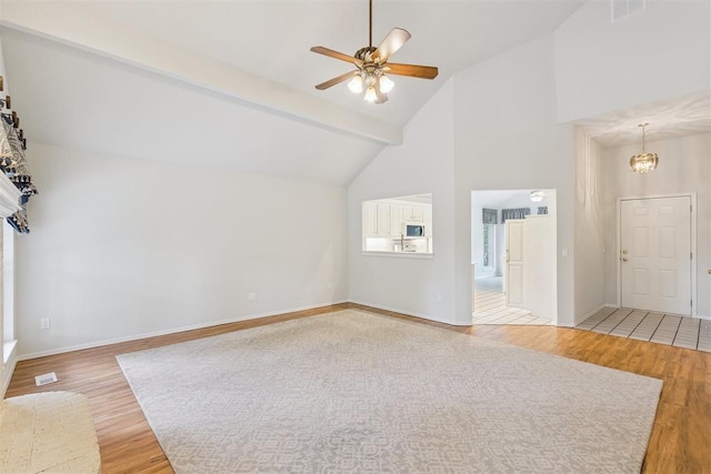 812 Old Bugle Rd, Edmond, OK 73003 - unfurnished living room featuring high vaulted ceiling, light wood-type flooring, a ceiling fan, beam ceiling, and a chandelier