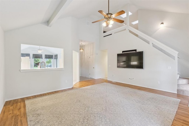 812 Old Bugle Rd, Edmond, OK 73003 - unfurnished living room featuring a ceiling fan, wood finished floors, stairway, high vaulted ceiling, and beamed ceiling