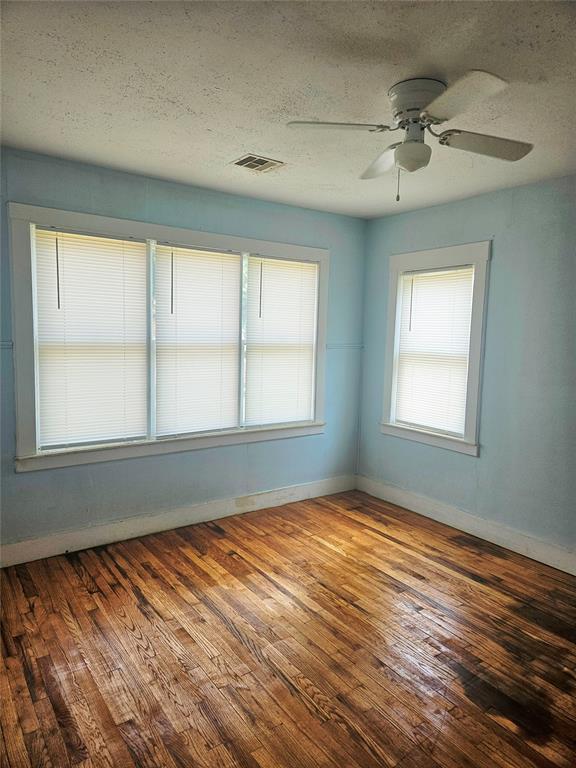 934 E Elm St, Altus, OK 73521 - spare room with a textured ceiling, hardwood / wood-style flooring, and ceiling fan