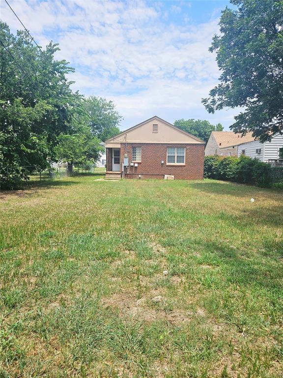 934 E Elm St, Altus, OK 73521 - rear view of house with brick siding and a lawn