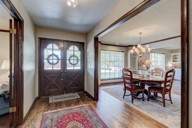 12108 Blue Sage Rd, Oklahoma City, OK 73120 - entrance foyer with healthy amount of natural light, wood finished floors, and a chandelier