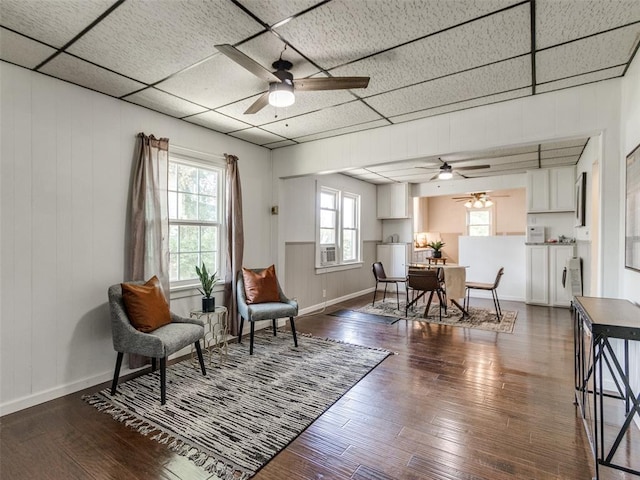 610 N Choctaw Ave, El Reno, OK 73036 - living area with ceiling fan, hardwood / wood-style flooring, wooden walls, and a drop ceiling