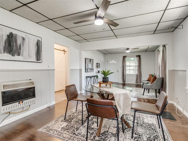 610 N Choctaw Ave, El Reno, OK 73036 - dining room with wood finished floors, heating unit, ceiling fan, a paneled ceiling, and wainscoting