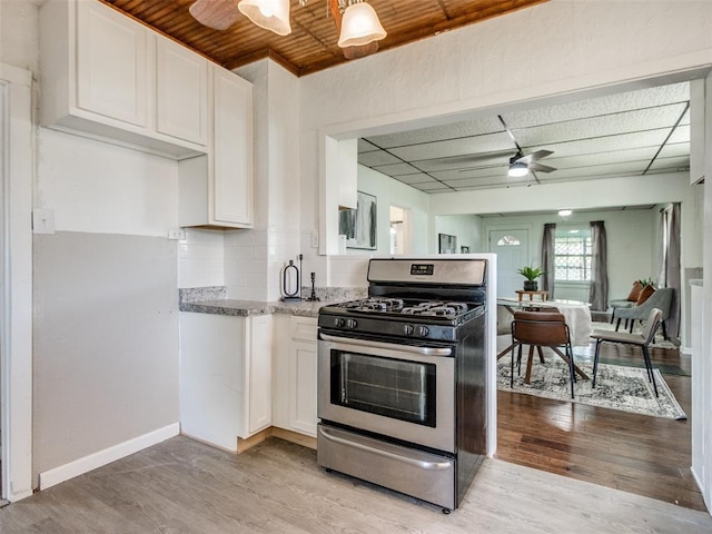 610 N Choctaw Ave, El Reno, OK 73036 - kitchen featuring stainless steel range with gas cooktop, ceiling fan, white cabinets, light stone countertops, and wood ceiling