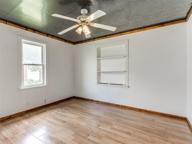 610 N Choctaw Ave, El Reno, OK 73036 - spare room featuring light wood-style floors, a ceiling fan, and built in shelves