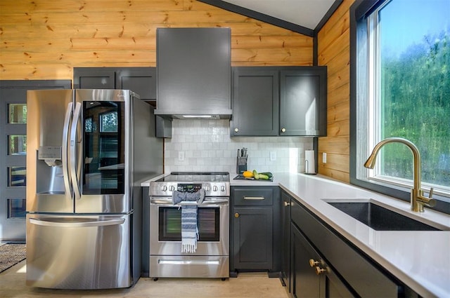 105 S Spruce Trl, Broken Bow, OK 74728 - kitchen with appliances with stainless steel finishes, extractor fan, healthy amount of natural light, tasteful backsplash, and wood walls