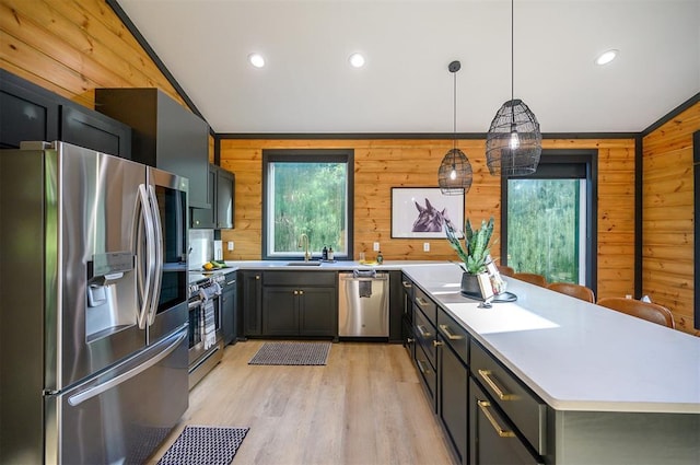 105 S Spruce Trl, Broken Bow, OK 74728 - kitchen featuring appliances with stainless steel finishes, wood walls, light countertops, lofted ceiling, and light wood finished floors