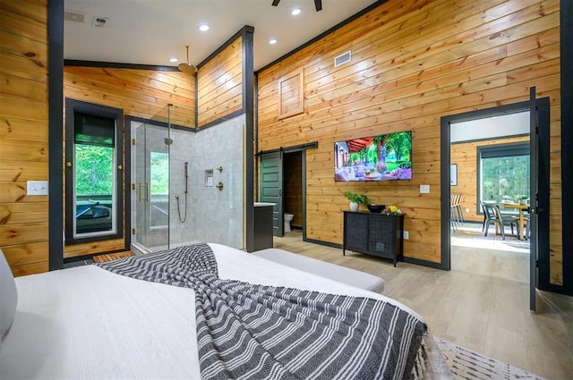 105 S Spruce Trl, Broken Bow, OK 74728 - bedroom featuring a barn door, wood walls, wood finished floors, recessed lighting, and access to outside