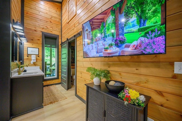 105 S Spruce Trl, Broken Bow, OK 74728 - doorway to outside with wooden walls, a barn door, and light wood finished floors
