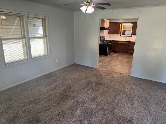 818 W Watts St, El Reno, OK 73036 - unfurnished living room featuring a ceiling fan, carpet flooring, and crown molding