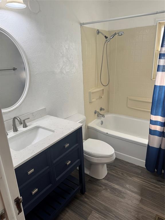 818 W Watts St, El Reno, OK 73036 - full bath featuring vanity, wood finished floors, shower / tub combo, and a textured wall