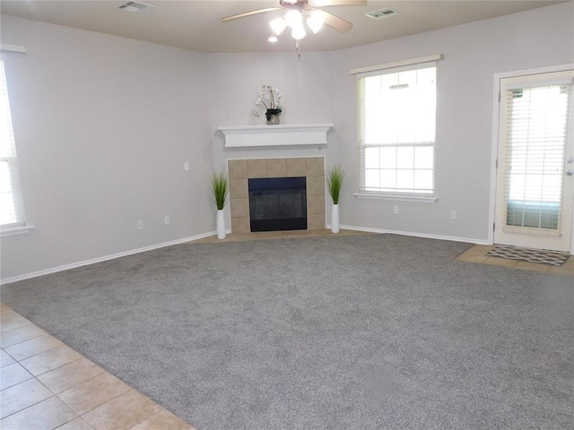 6036 SE 66th St, Oklahoma City, OK 73135 - unfurnished living room with ceiling fan, a tiled fireplace, tile patterned flooring, and carpet