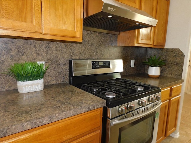 6036 SE 66th St, Oklahoma City, OK 73135 - kitchen featuring stainless steel gas range oven, extractor fan, dark countertops, decorative backsplash, and light tile patterned floors