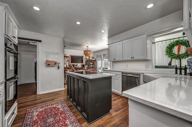 1601 Hazelhurst, Edmond, OK 73013 - kitchen with appliances with stainless steel finishes, a kitchen island, dark wood-style floors, light countertops, and recessed lighting