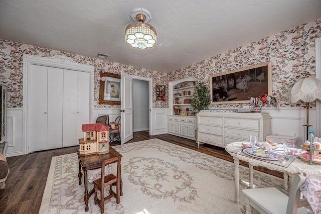 1601 Hazelhurst, Edmond, OK 73013 - living area with wallpapered walls, a wainscoted wall, and dark wood-style flooring