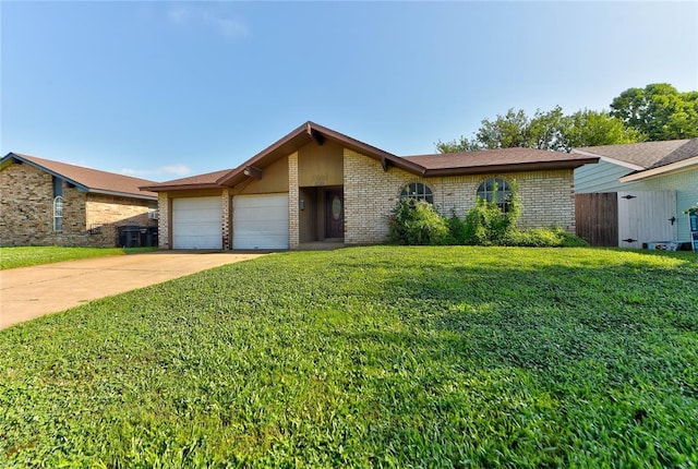 1021 SW 1st St, Moore, OK 73160 - view of front of house featuring brick siding, a garage, a front yard, and driveway