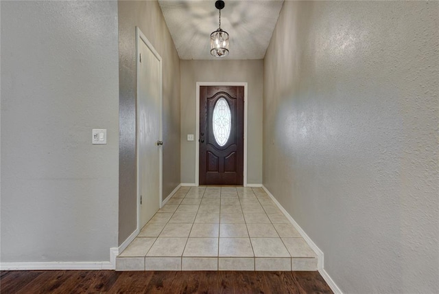 1021 SW 1st St, Moore, OK 73160 - doorway to outside featuring a textured wall, a chandelier, and light tile patterned floors