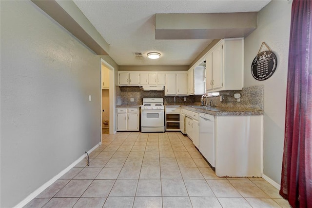 1021 SW 1st St, Moore, OK 73160 - kitchen with white appliances, decorative backsplash, light tile patterned floors, white cabinetry, and a textured ceiling