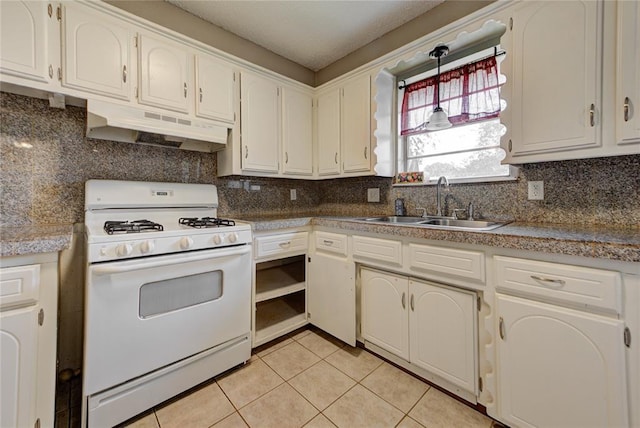 1021 SW 1st St, Moore, OK 73160 - kitchen with gas range gas stove, under cabinet range hood, light tile patterned flooring, tasteful backsplash, and white cabinets