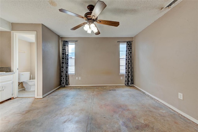 1021 SW 1st St, Moore, OK 73160 - unfurnished bedroom featuring a textured ceiling, concrete floors, ensuite bathroom, and a ceiling fan